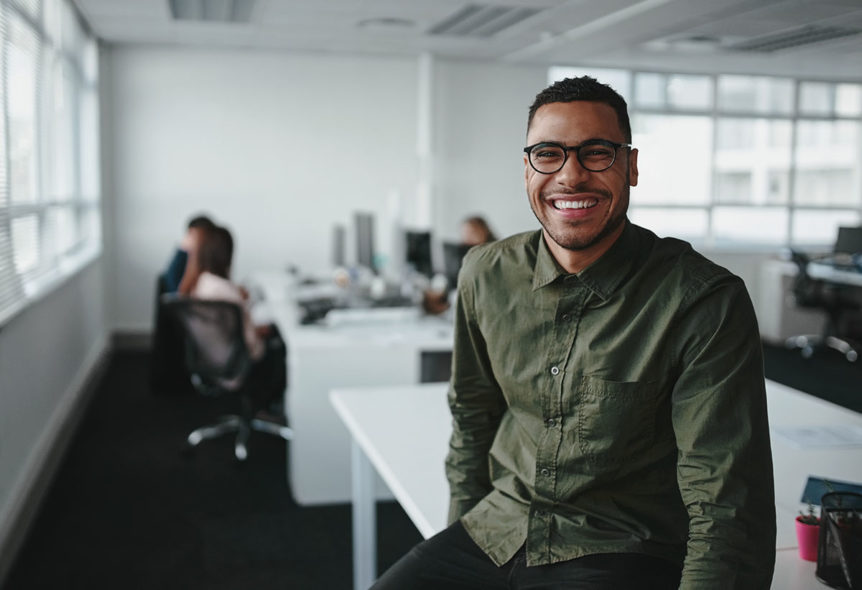 person smiling in office after learning how healthcare improves productivity